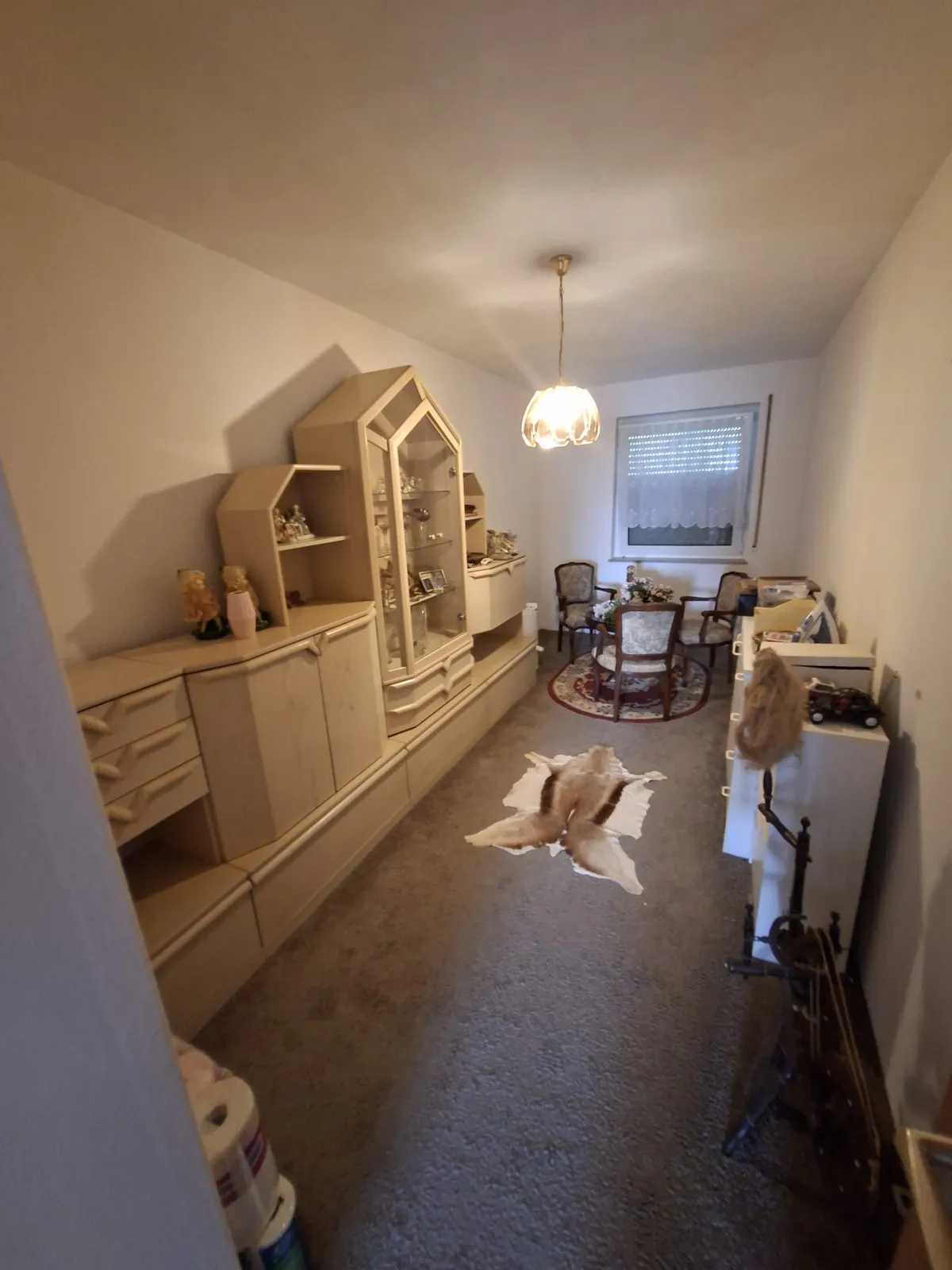 Wohnzimmer mit Schrankwand und Hausrat vor der Entrümpelung